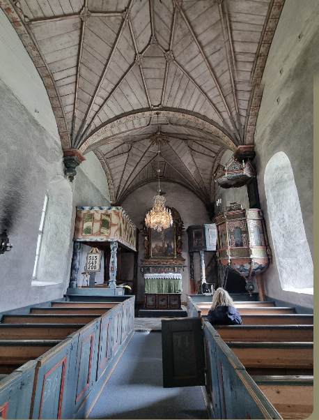 Kyrkorummet i Åre gamla kyrka med målade bänkar och valv